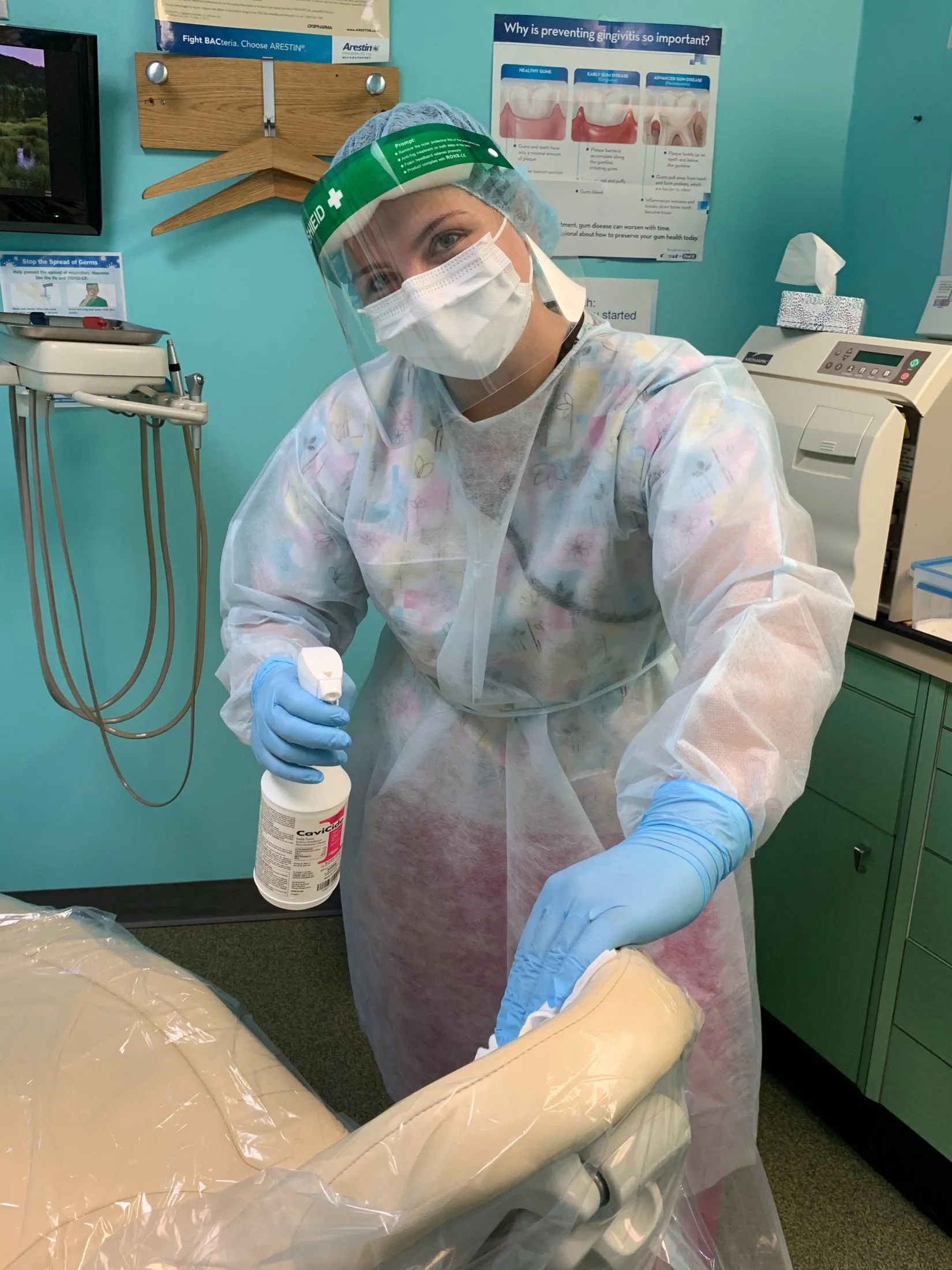 Staff member sanitizing a work station